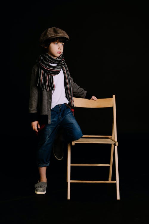 男孩抱着棕色的木椅 · 免费素材图片