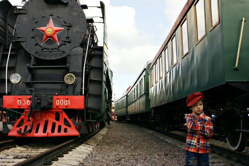 站在大火车之间的男孩 · 免费素材图片