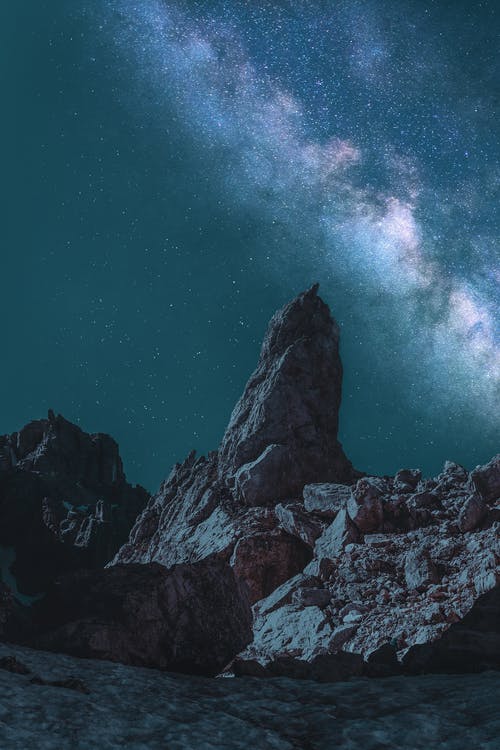 蓝绿色和银河系下的棕色巨石 · 免费素材图片