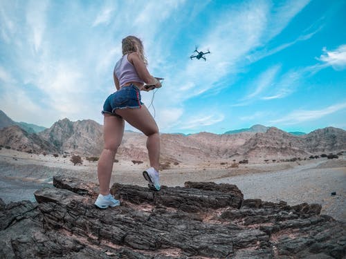 低角度拍摄的飞行无人机的女人 · 免费素材图片