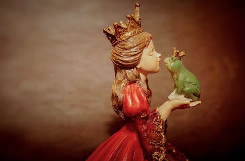 女人穿着皇冠拿着青蛙雕像 · 免费素材图片