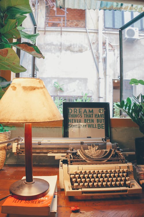 台灯旁边的白色打字机 · 免费素材图片