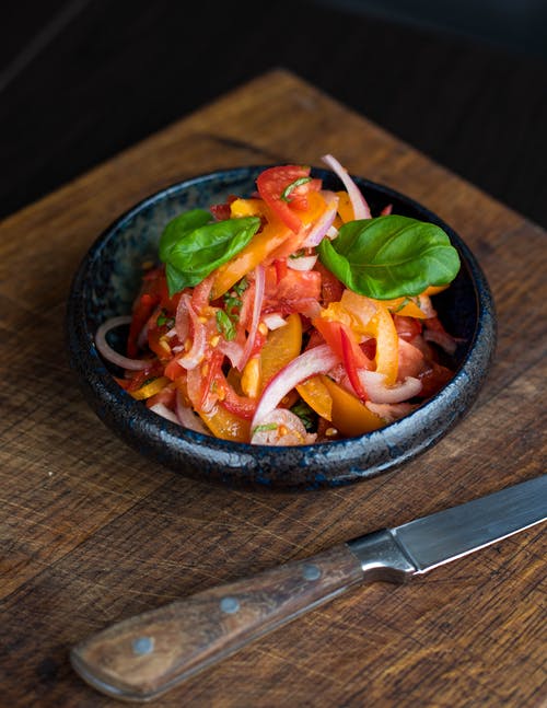 番茄沙拉在刀旁边的盘子 · 免费素材图片