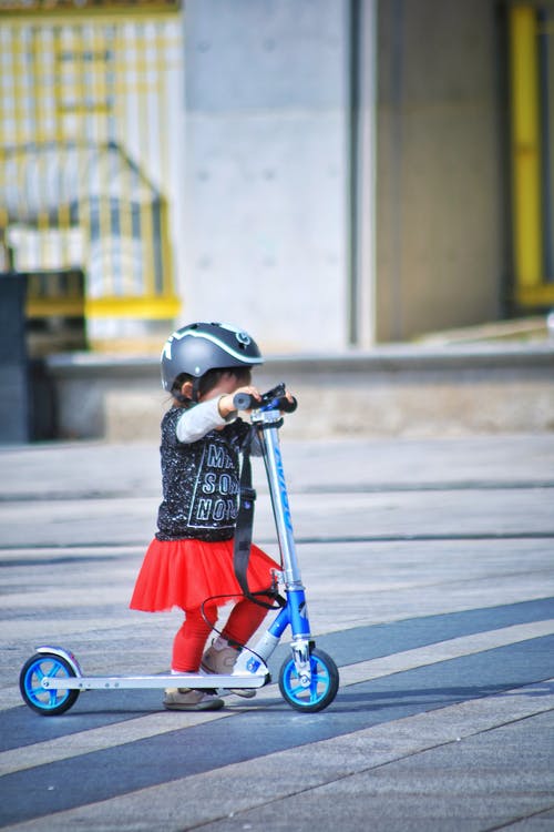 蹒跚学步的道路上使用踏板车 · 免费素材图片