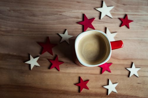 红色陶瓷杯咖啡棕色表面上 · 免费素材图片