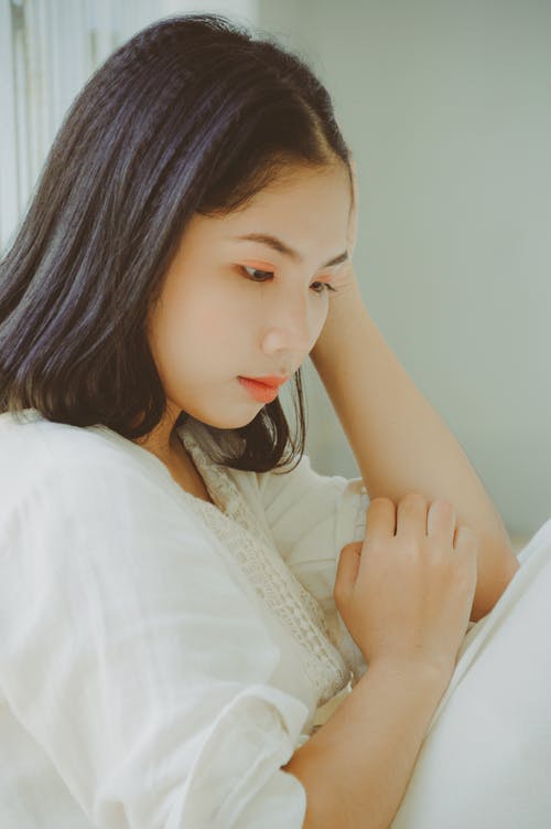 女人靠在白墙附近 · 免费素材图片