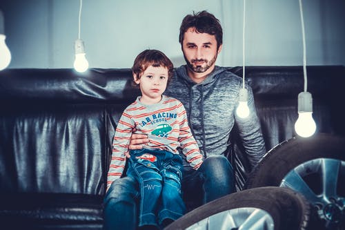 男人坐在女孩旁边的沙发椅上 · 免费素材图片