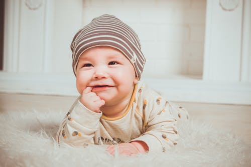 微笑的婴儿咬右食指 · 免费素材图片