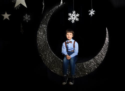 男孩坐在月亮装饰 · 免费素材图片