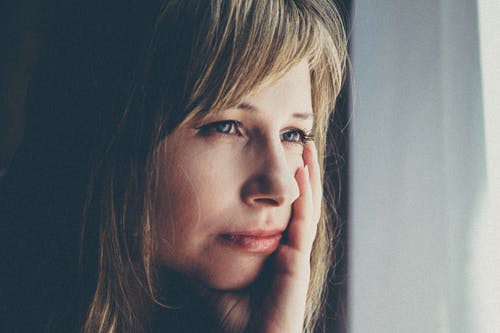 女人触摸她的左脸颊的浅焦点摄影 · 免费素材图片