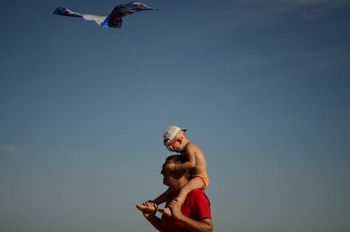 蹒跚学步的男孩在男人的肩膀上 · 免费素材图片