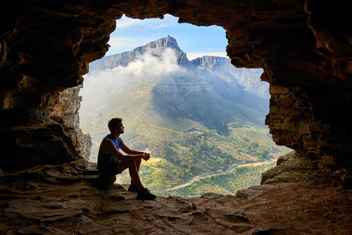 男子坐在一个山洞里的照片 · 免费素材图片