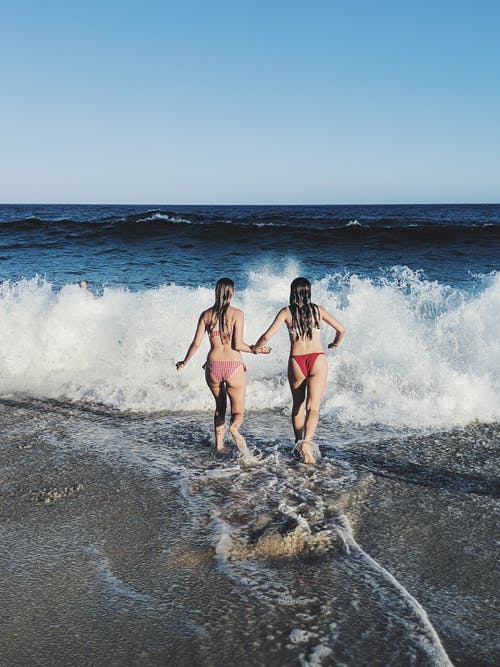 比基尼的妇女奔向海岸 · 免费素材图片