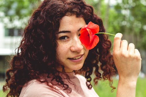 女人拿着红色的花 · 免费素材图片