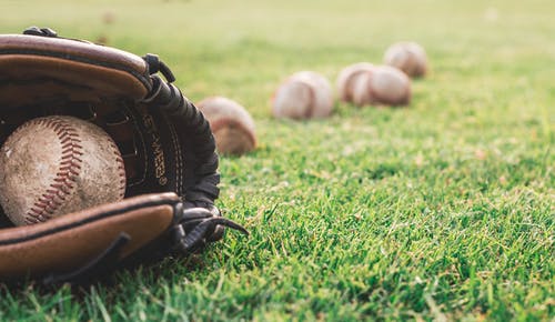 棕色皮革棒球手套上的白色棒球球 · 免费素材图片