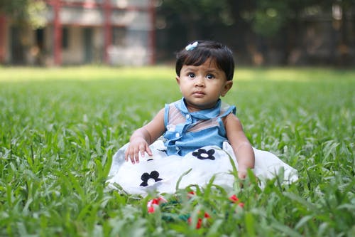 婴儿坐在草地上的照片 · 免费素材图片