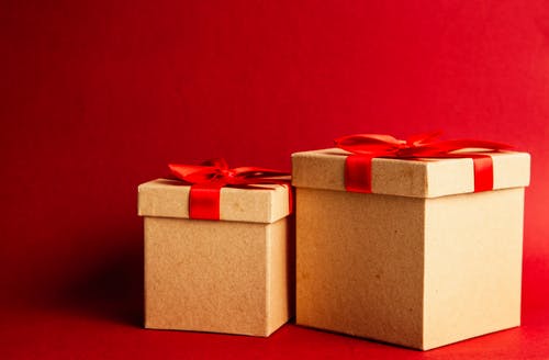 红色表面上的两个棕色和红色礼品盒 · 免费素材图片