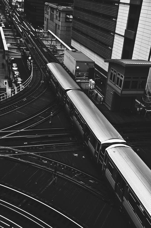大厦旁边火车的灰度摄影 · 免费素材图片