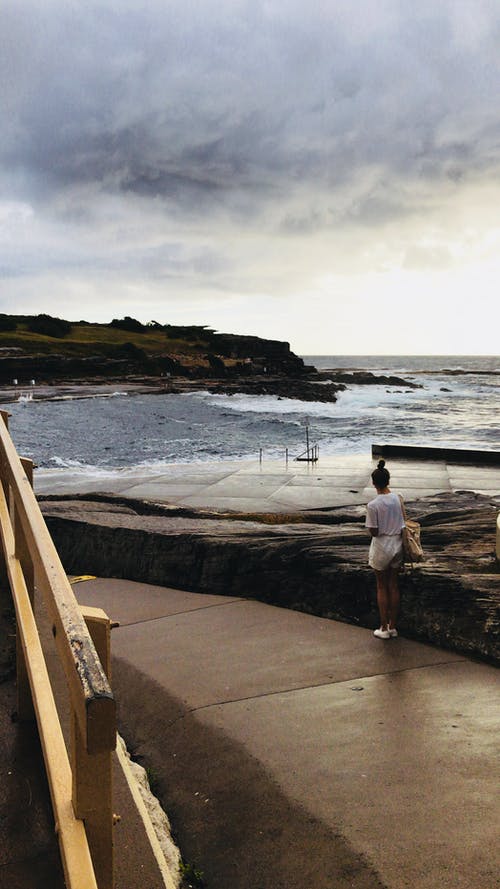 站在大水附近的白色短裤的女人 · 免费素材图片