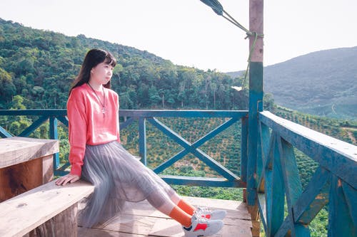 女人坐在木凳上的照片 · 免费素材图片