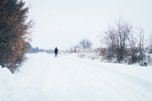 在白雪覆盖的土路上行走的人 · 免费素材图片