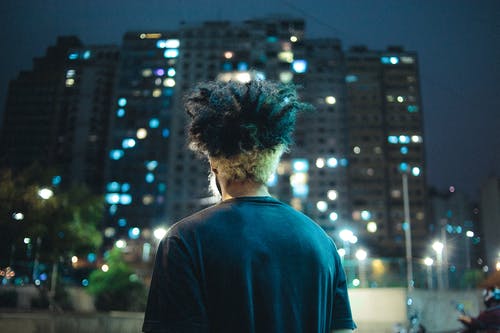 面对高层建筑的男人穿着黑色衬衫 · 免费素材图片