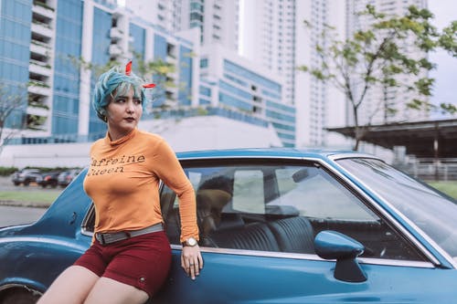 女人靠在蓝色轿跑车 · 免费素材图片
