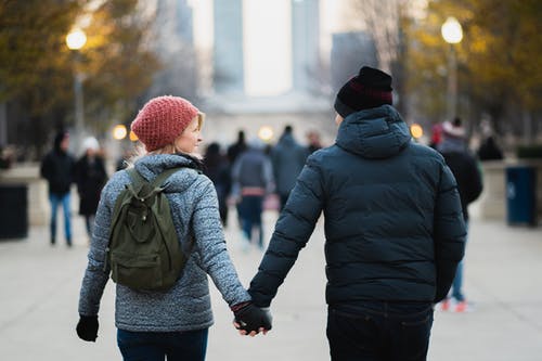 男人和女人在公园散步时手牵着手 · 免费素材图片