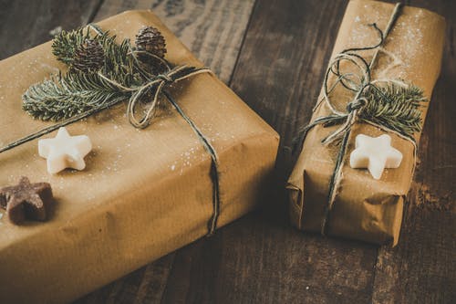 在木桌上的两个棕色包装的礼物的照片 · 免费素材图片