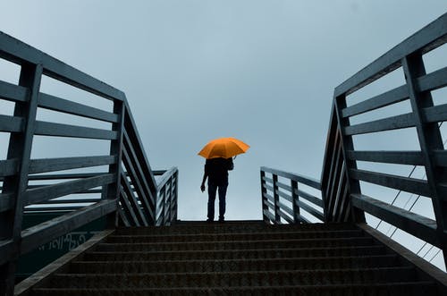 拿着伞的人站立在台阶上 · 免费素材图片