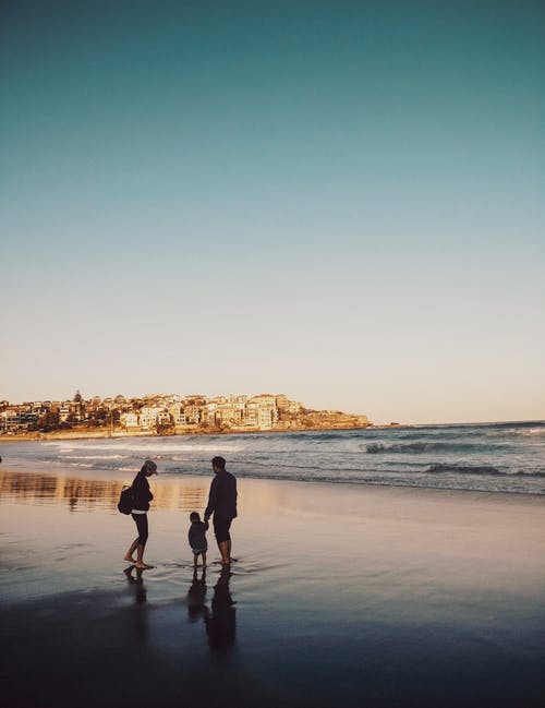 男人和女人和男孩在海边散步 · 免费素材图片