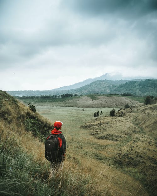面对布朗山的男人的风景照片 · 免费素材图片