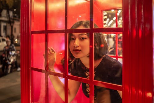红色电话亭内的女人 · 免费素材图片