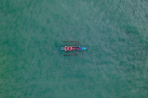 在水体上的红色和棕色独木舟 · 免费素材图片