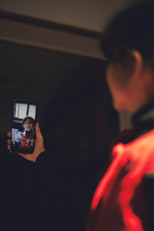 女孩抱着黑色的android智能手机 · 免费素材图片