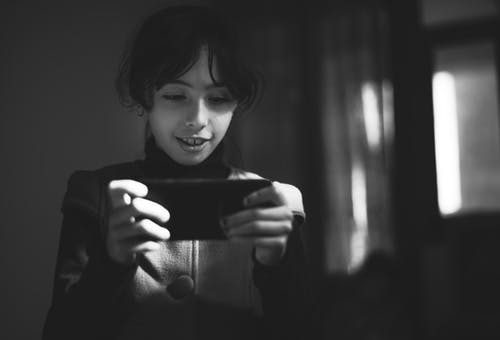 使用智能手机的女孩的灰度摄影 · 免费素材图片