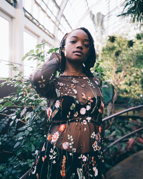 女人站在绿色的植物 · 免费素材图片