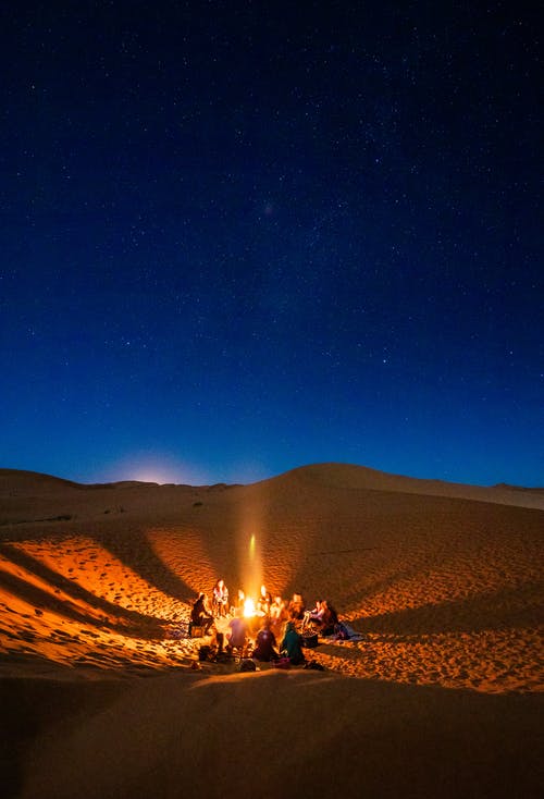 夜间坐在沙漠篝火前的人们 · 免费素材图片