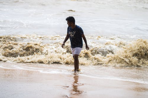 男子在岸上行走的照片 · 免费素材图片