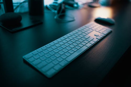 带数字键盘的apple Magic键盘在无线鼠标附近的桌子上 · 免费素材图片
