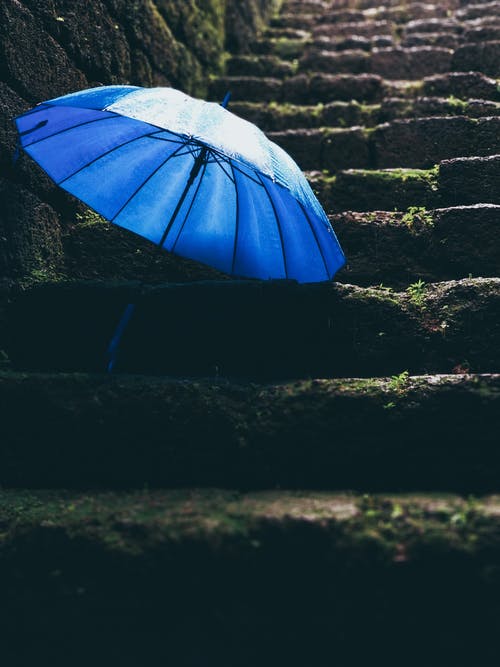 黑色楼梯上的蓝色雨伞 · 免费素材图片