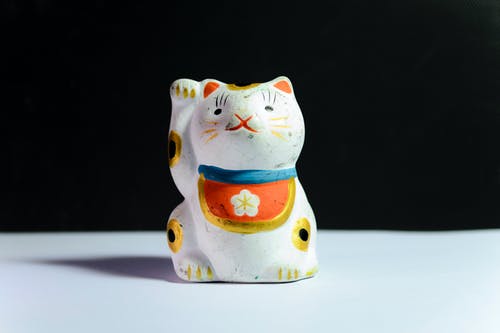 白色表面上的招财猫雕像 · 免费素材图片