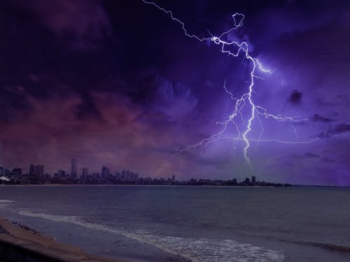 城市和海洋附近的闪电现象 · 免费素材图片