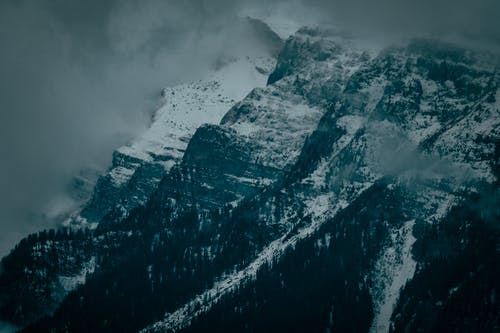 白雪皑皑的山脉，在多云的天空下 · 免费素材图片