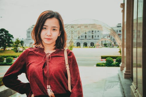 站在户外的红色长袖上衣的女人的照片 · 免费素材图片