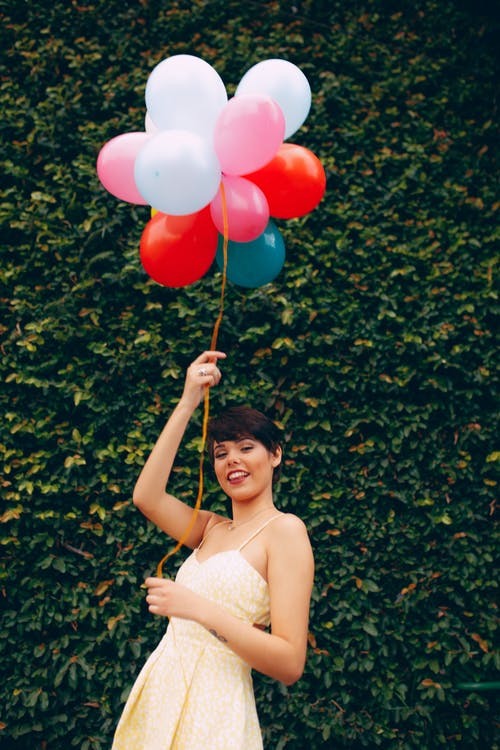 微笑的女人，拿着气球的照片 · 免费素材图片
