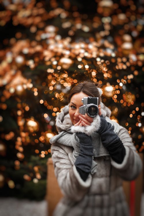 女人在冬季大衣的照片拍张照片 · 免费素材图片
