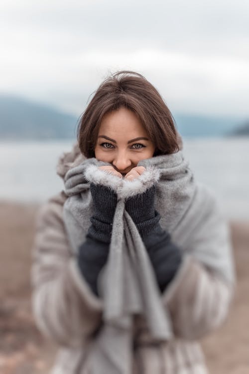 女人用围巾覆盖嘴的选择性焦点 · 免费素材图片