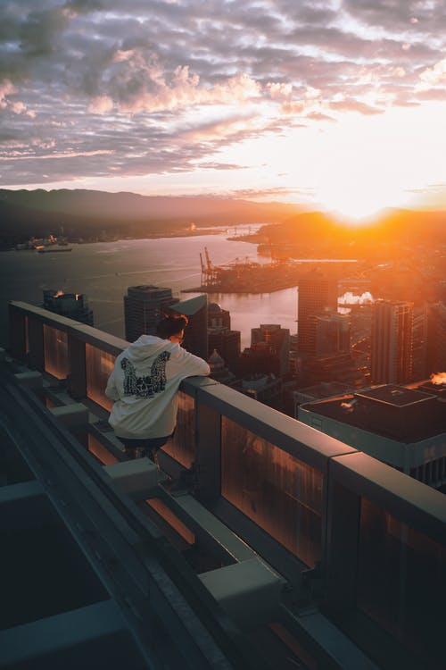 坐在栅栏旁边的男人 · 免费素材图片