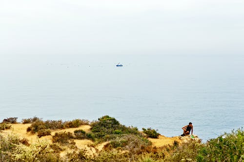 男子坐在悬崖上 · 免费素材图片